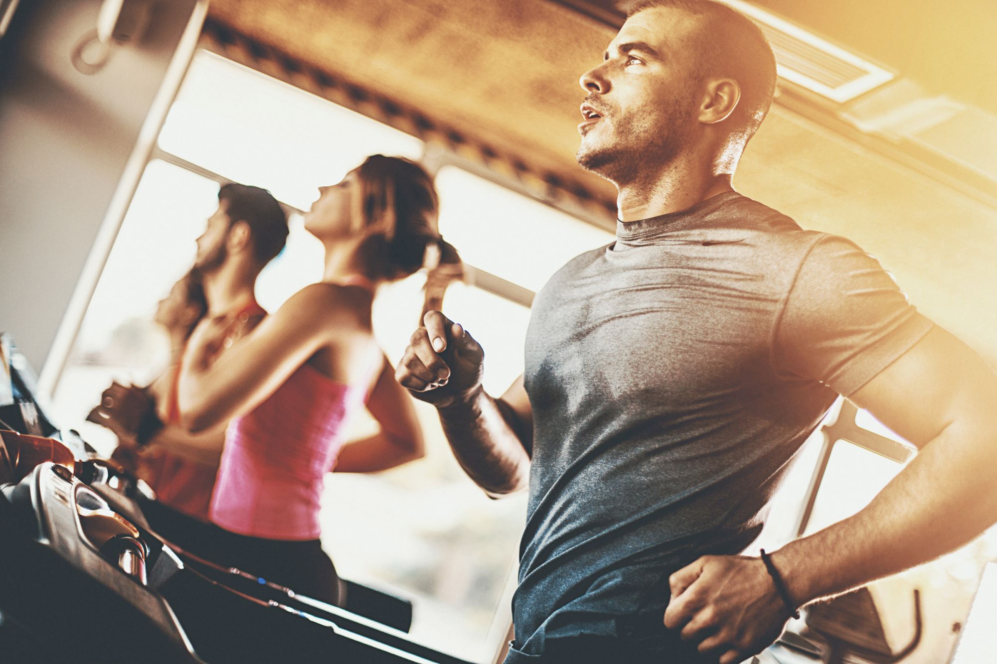 People running on treadmills indoors, capturing a focused and energetic workout atmosphere.